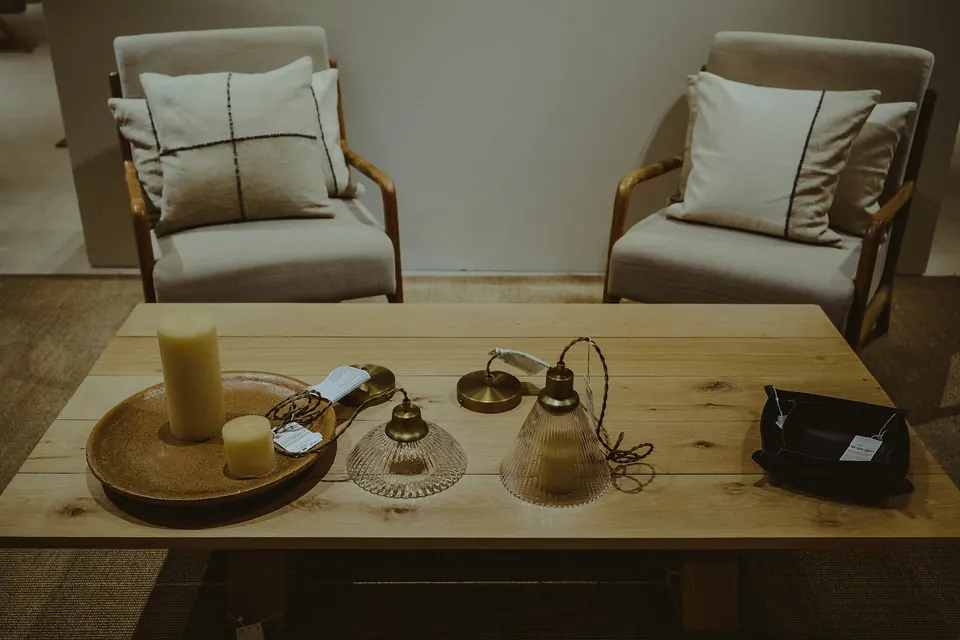 Two armchairs and a low wooden table with candles in a softly lit room